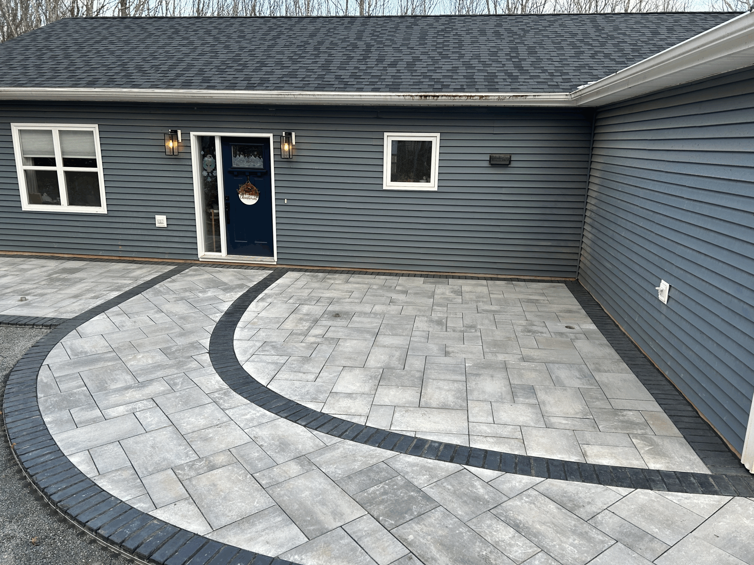 Custom driveway installation featuring interlocking pavers and a curved border, enhancing curb appeal and durability for residential properties.