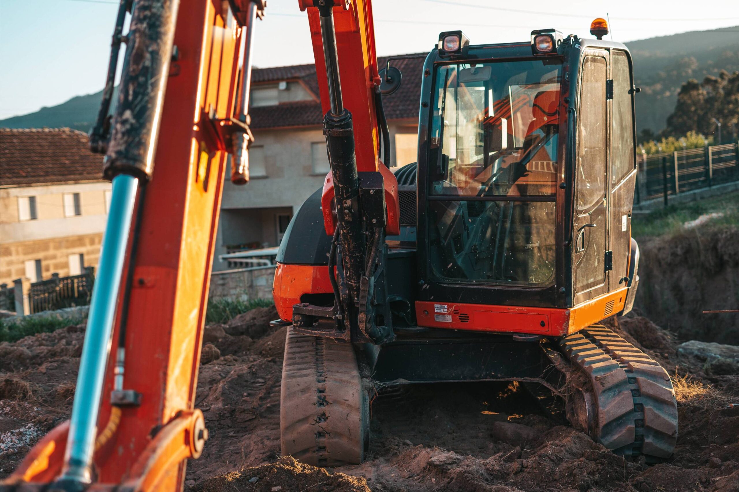 Excavator on construction site with visible tracks and hydraulic arm, showcasing McIsaac Lawncare's professional excavation services for grading and land clearing.
