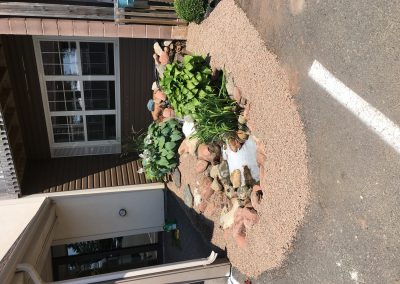 Landscaped garden area with rocks, plants, and gravel, showcasing McIsaac Lawncare's outdoor transformation and craftsmanship.