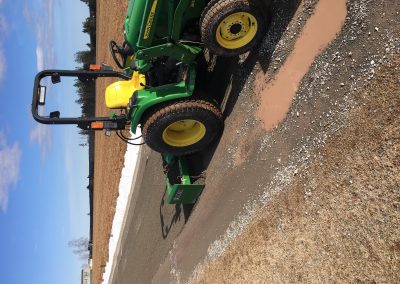 John Deere tractor in action, leveling gravel for landscaping project, showcasing McIsaac Lawncare's outdoor transformation expertise.